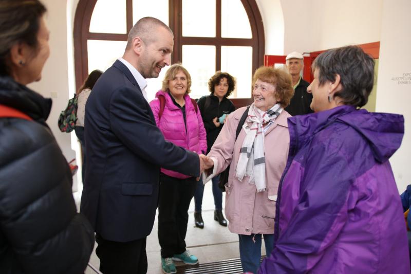 Employees of Beit Theresienstadt in the Terezín Memorial; pictured on the left is Mr. Jan Roubínek, Director of the Terezín Memorial, shaking hands with Mrs. Dita Krausová (center); on the right is Mrs. Tamy Kinberg, Director of Beit Theresienstadt. Photo: Radim Nytl, Terezín Memorial.